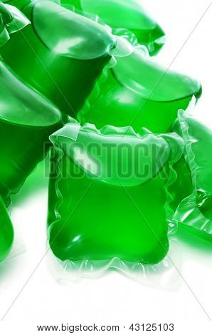 un mucchio di bustine detersivo bucato liquido su uno sfondo bianco
