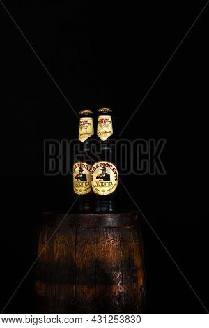 Bottle Of Birra Moretti Beer On Wooden Barrel With Dark Background. Illustrative Editorial Photo Buc