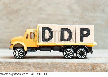 Toy Truck Hold Alphabet Letter Block In Word Ddp (abbreviation Of Delivered Duty Paid) On Wood Backg