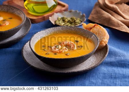 Pascetarian Autumn Homemade Pumpkin And Carrot Cream Puree Soup With Prawn, Seedsand Toast On Plate 