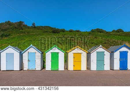 Colourful Beach Houses. Row Of Multicolored Beach Huts Against Blue Sky.