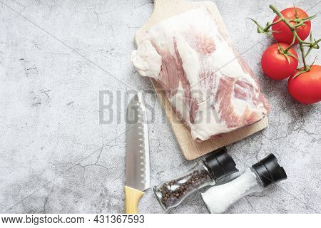 Piece Of Raw Pork On A Gray Background. Fresh Meat Is Ready To Cook. View From Above