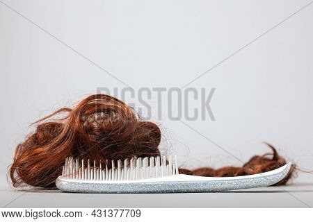 A White Comb With False Hair. Side View. White Background. Copy Space. The Concept Of Hair Problems 