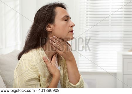 Mature Woman Doing Thyroid Self Examination At Home. Space For Text
