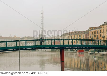 Unrecognisable Couple Standing On Alexander Langer Bridge, Darsena Waterfront On Foggy Winter Mornin