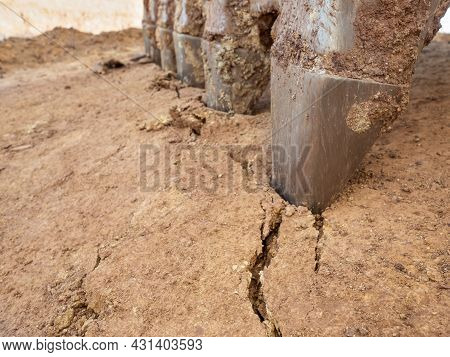 Alloed Steel Teeth Of The Excavator Bucket Bite The Dry Clay. Cracked Ground Under Strong Hydraulic 