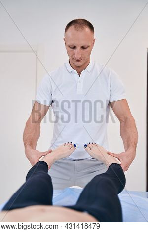 Strong Muscular Male Reflexologist Helping Unrecognized Woman With Exercises In Rehabilitation Cente