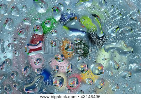 Goccia d'acqua colorata su sfondo di vetro