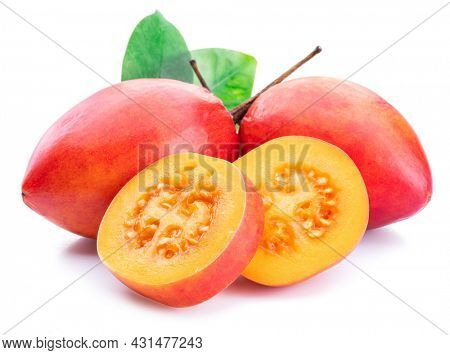 Ripe tamarillo fruits with slices and tamarillo leaves isolated on a white background.