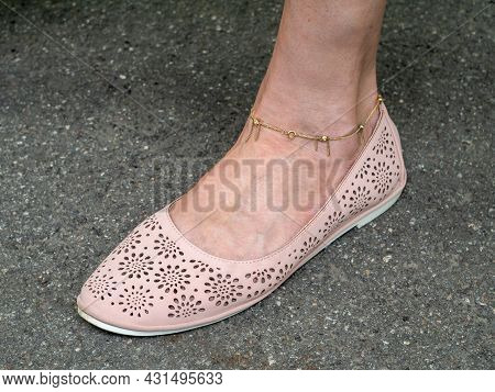 A Woman's Leg With A Gold Bracelet At The Ankle, Shod In Summer Shoes. Close-up.