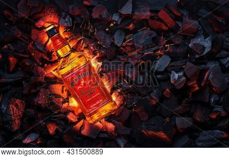 Ukraine, Kiev. November 12, 2020. Bottle of Jack Daniels Whiskey Tennessee Fire top view in burning coals.