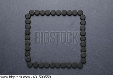 Frame Of Activated Charcoal Pills On Grey Background, Flat Lay With Space For Text. Potent Sorbent