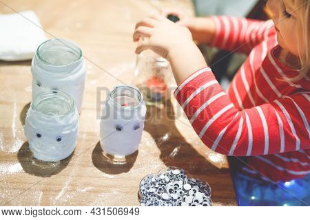Little Toddler Girl Making Ghost Lanterns For Halloween Party. Cute Preschool Child Doing Handicraft