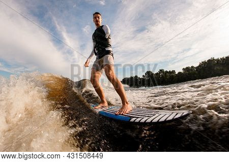 Armless Man Is Surfing On Surfboard Trails Behind Boat. Wakesurfing On The River
