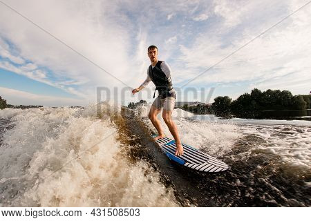 Active Armless Man Is Surfing On Surfboard Trails Behind Boat. Wakesurfing On The River