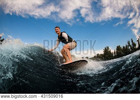Armless Man Wakesurfing On The Board Down The Wave Against The Background Of Sky