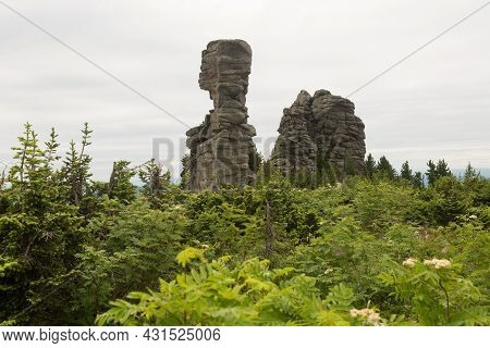 Large Kurum Stones Lie In The Forest In The Mountains, Stones Covered With Moss, Against The Backgro