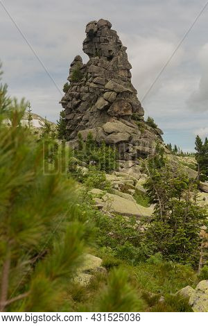 Large Kurum Stones Lie In The Forest In The Mountains, Stones Covered With Moss, Against The Backgro