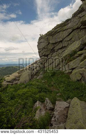 Large Kurum Stones Lie In The Forest In The Mountains, Stones Covered With Moss, Against The Backgro