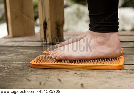 Practice Of Standing On Nails. Close-up Of A Yoga Man Standing On A Sadhu Board With Sharp Nails. Wo