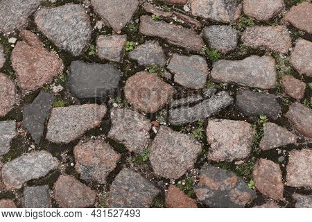 Background From An Old, Medieval Cobblestone, Composed Of Cobblestones Of Different Sizes In Close-u