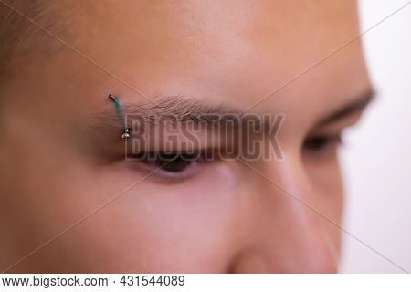 Man With Pierced Eyebrow. Three Small Black Piercings.