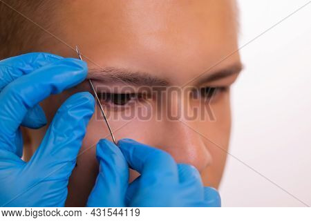 Man With Pierced Eyebrow. Three Small Black Piercings.