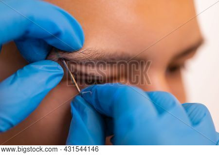Man With Pierced Eyebrow. Three Small Black Piercings.