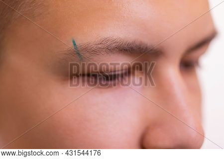 Man With Pierced Eyebrow. Three Small Black Piercings.