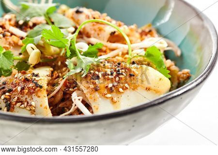 Pan asian traditional dish - fried rice with egg, vegetables, and squid. Indian wok with rice, egg and kalmar on white background. Nasi goreng with calamari on isolated background with shadows
