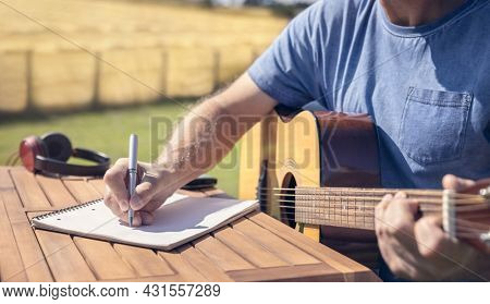 Musician guitarist songwriter playing acoustic guitar and writing music
