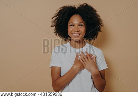 Gratitude Concept. Happy Thankful Young African Woman Isolated On Yellow Studio Background Holding H