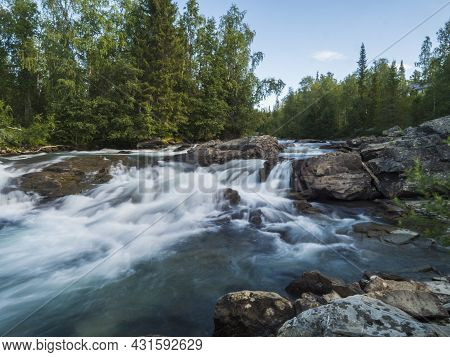 Beautiful Landscape With Long Exposure Water Stream And Cascade Of River Kamajokk, Boulders And Spru