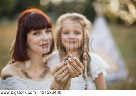 Close Up Small Frog In Hands Of Beautiful Young Woman. Blurred View Of Smiling Mother And Cute Daugh
