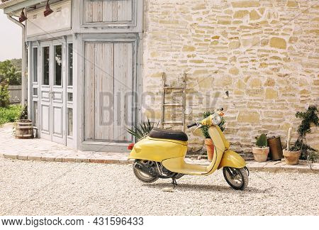 Nostalgic Yellow Scooter And Plants By Vintage Building, Retro Lifestyle With Copy Space