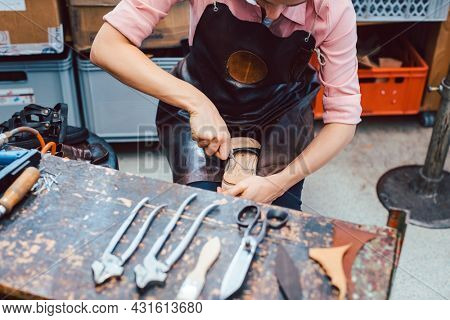 Shoemaker working on the frame of a shoe