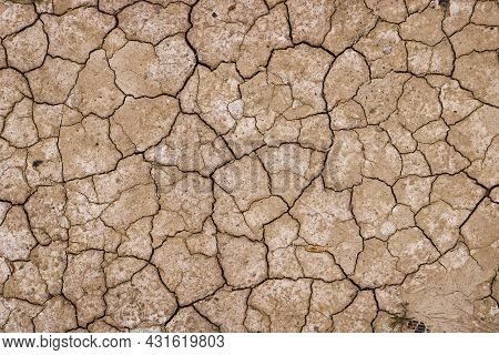 Drought Cracked Land. Water Crisis Concept, Seasonal Water Scarcity. Dried Soil Texture.
