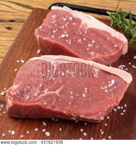 Sliced Raw Ancho Beef, Typical Argentinian Cut, Over Wooden Board With Seasonings.