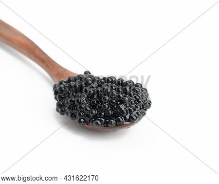 Fresh Grainy Black Paddlefish Caviar In Brown Wooden Spoon On White Background, Close Up
