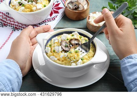 Woman Eating Traditional Banosh At Blue Wooden Table, Closeup