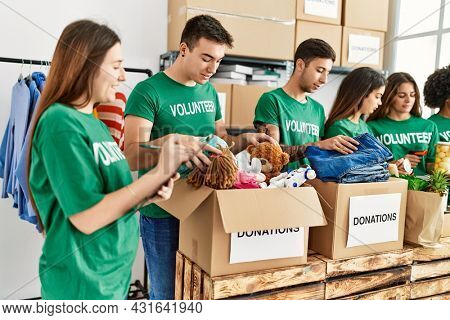 Group of young volunteers smiing happy working at charity center.