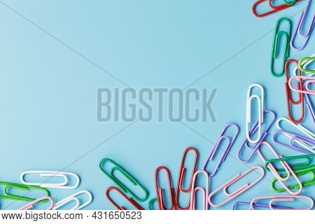 Multicolored Paper Clips On A Blue Background.