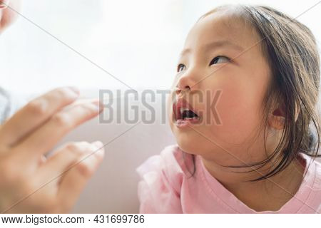 Adorable Asian Girl Kid Getting Swab Test At Home By Her Parent. Rapid Self Test For Covid-19, Antig