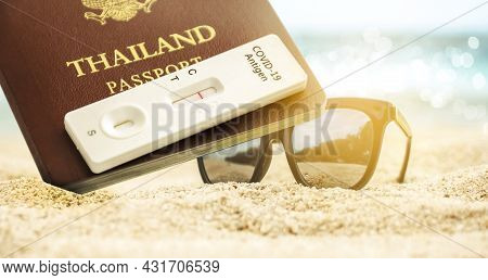 Thailand Passport And Covid-19 Antigen Test Kit With Negative Test Result And Sunglass Placing On Th