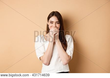 Happy Girl Laughing And Covering Mouth With Hands, Hiding Her Smile And Chuckle Over Something Funny