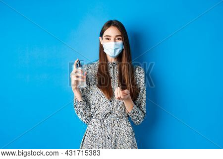 Covid-19, Social Distancing And Healthcare Concept. Beautiful Girl In Medical Mask Using Hand Sanizi