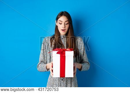 Holidays. Surprised Young Woman Looking At Gift With Amazed Face, Receive Valentines Day Present, St