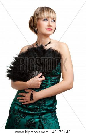 สาวสวยในชุดราตรีสีเขียวพร้อมพัดลม hodling สร้อยคอและต่างหู