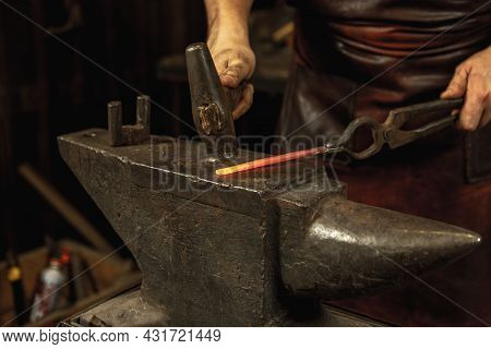 Close-up Working Powerful Hands Of Male Blacksmith Forge An Iron Product In A Blacksmith. Hammer, Re