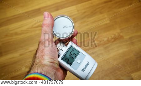 Paris, France - Apr 21, 2020: Pov Man Hand Holding Two New Electronic Thermostatic Heads - Vaillant 